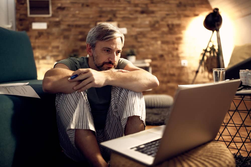 Man using laptop at home during virtual mental health IOP session in Greensboro NC