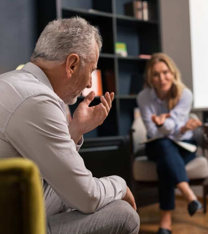 Man speaking with therapist during addiction treatment programs in Greensboro, North Carolina.