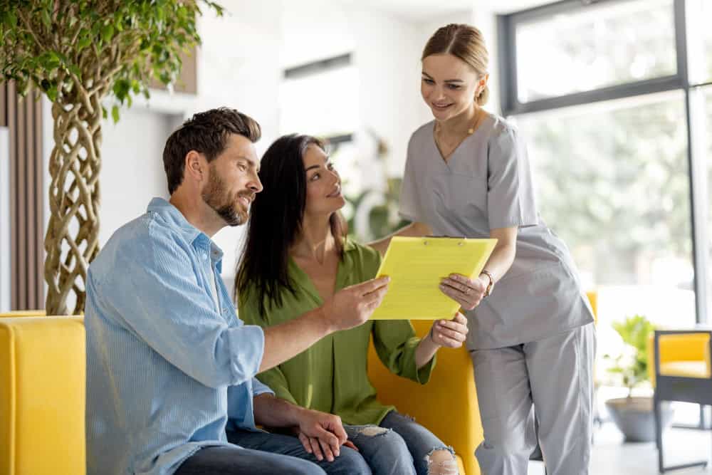 Nurse speaking with patients in a clinic waiting room.